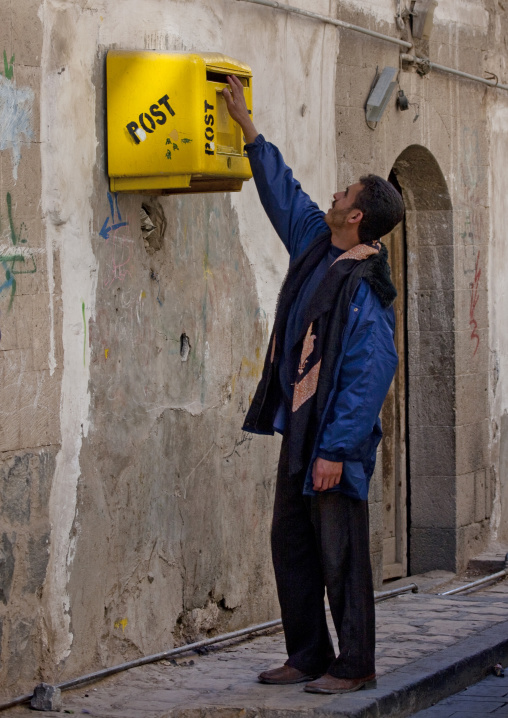 Man Posting Letters In A Strangely Highly Placed Yellow Mailbox, Sanaa, Yemen