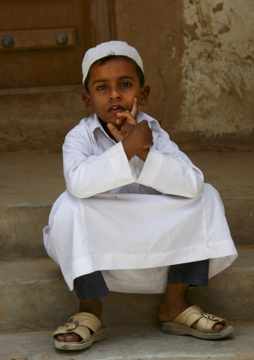 Yemeni Boy With White Taqiyah Sitting On Doorstep, Tarim, Yemen