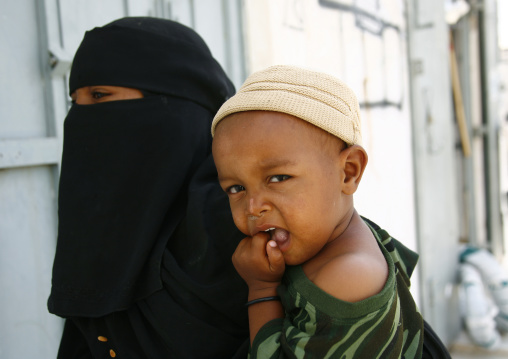 Yemeni Mother Wearing Niqab And Holding A Baby On Her Hip, Tarim, Yemen