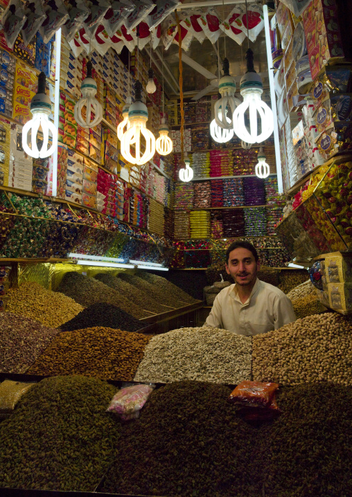 Smiling Shop Keeper Among Piles Of Snacks, Sanaa's Souq, Yemen