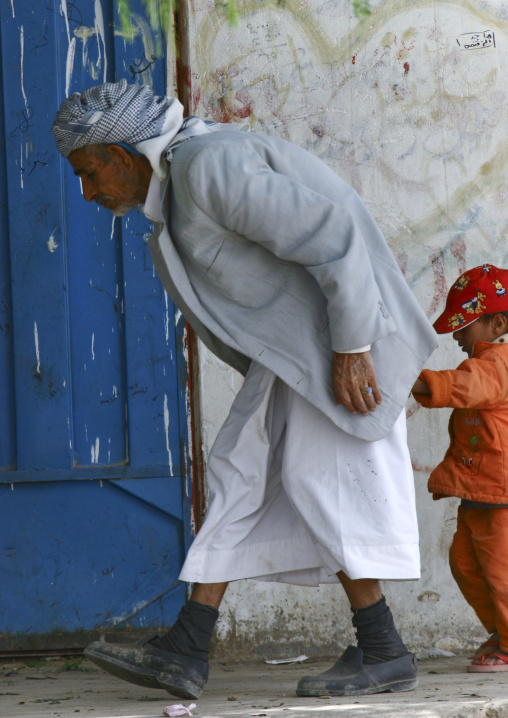 Old Bent Man Holding A Kid Hand In The Street, Yemen