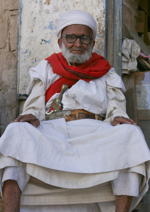 Proud Old Yemeni Man With Glasses And Dagger Sitting In Front Of A Shop, Rada,  Yemen