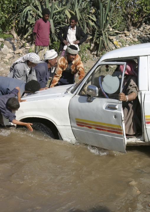 Group Of Men Trying To Help A Car Crossing A Wadi, Yemen