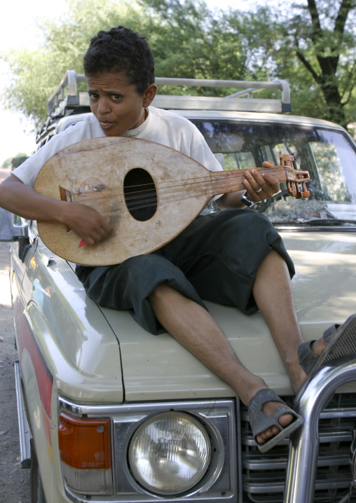 Boy Playing Oud On A Car, Thiama, Yemen