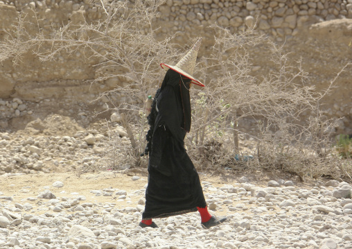 Hadramaut Woman Dressed In Black And Wearing A Cone Hat Passing By, Hadramaut, Yemen