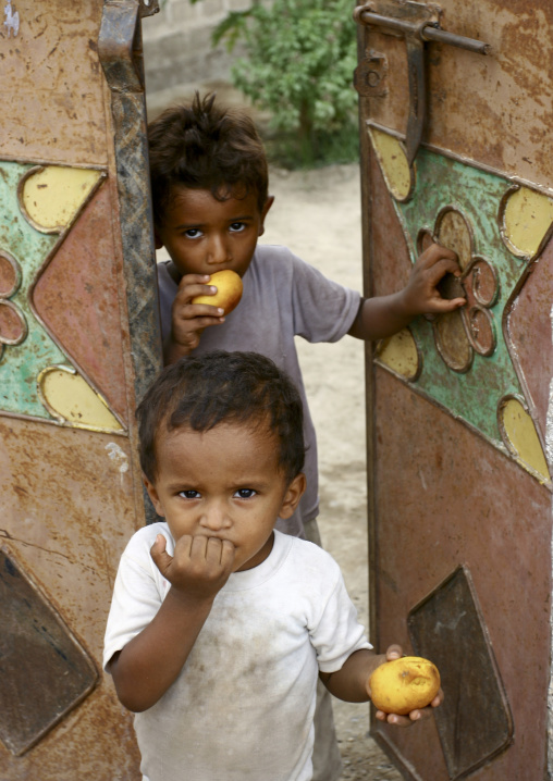 Two Young Boys Eating Fruits At A Door, Zabid, Yemen