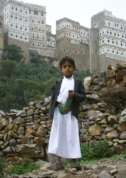 Little Boy Holding  A Jambiya In Front Of Al Hajjara, Yemen
