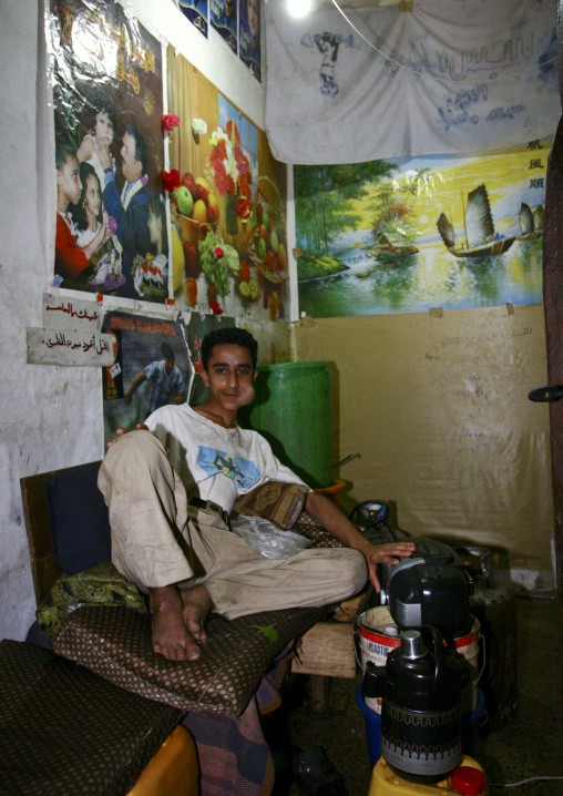 Young Man Lying Down And Chewing Qat In A Room Full Of Posters, Sanaa, Yemen