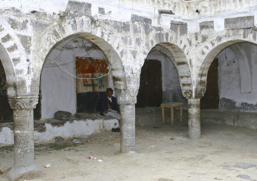 Man Sitting Under The Arcades Of Sanaa's Caravanserai, Yemen