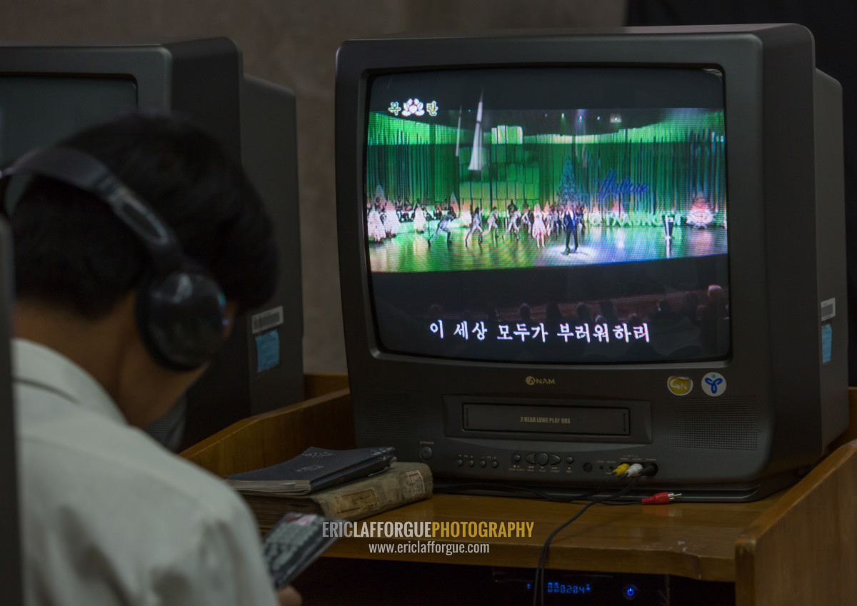 ERIC PHOTOGRAPHY North Korean man watching a video tape in the multimedia room of