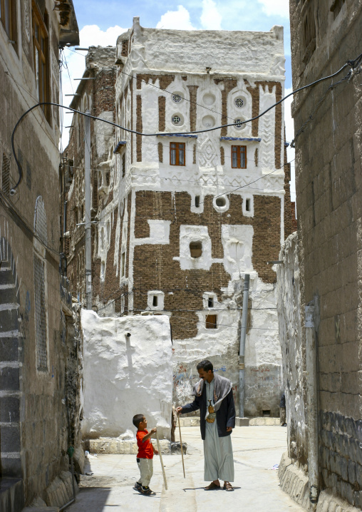 Yemeni people in front of traditional houses in the old city, Amanat Al-Asemah, Sanaa, Yemen