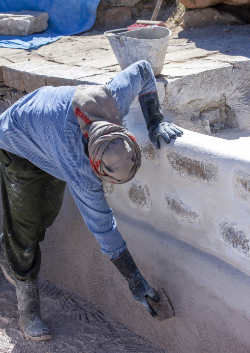 Yemeni worker putting limestone on a mosque, Amran Governorate, Thula, Yemen
