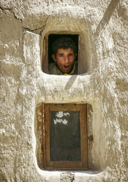 Yemeni man looking thu a window, Amran Governorate, Amran, Yemen