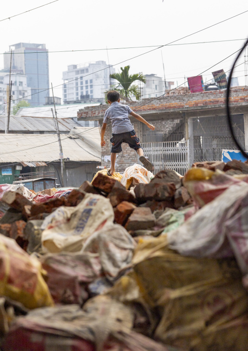 Bangladeshi boy playing in a garbage dump, Dhaka Division, Dhaka, Bangladesh