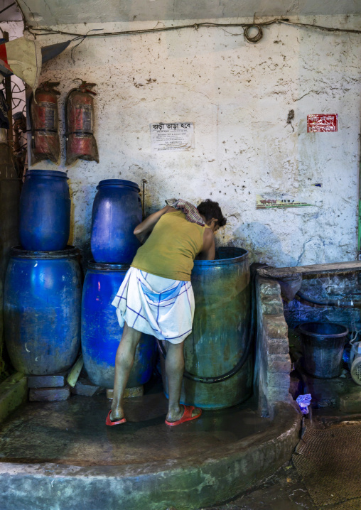 Bangladeshi man filling barrels in Kawran bazar, Dhaka Division, Dhaka, Bangladesh