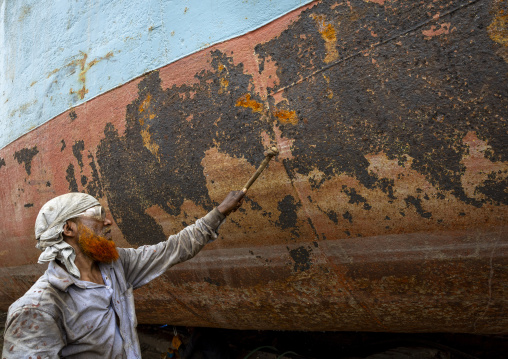 Worker at Dhaka Shipyard removing rust, Dhaka Division, Keraniganj, Bangladesh