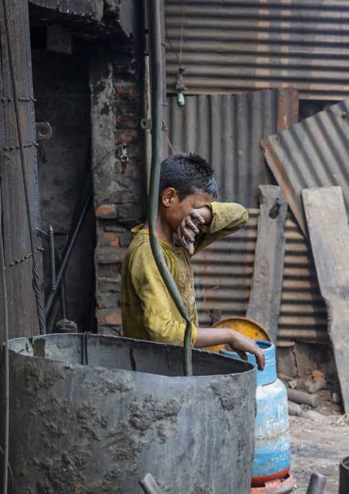 Bangladeshi boy cleaning his eyes at Dhaka Shipyard, Dhaka Division, Keraniganj, Bangladesh