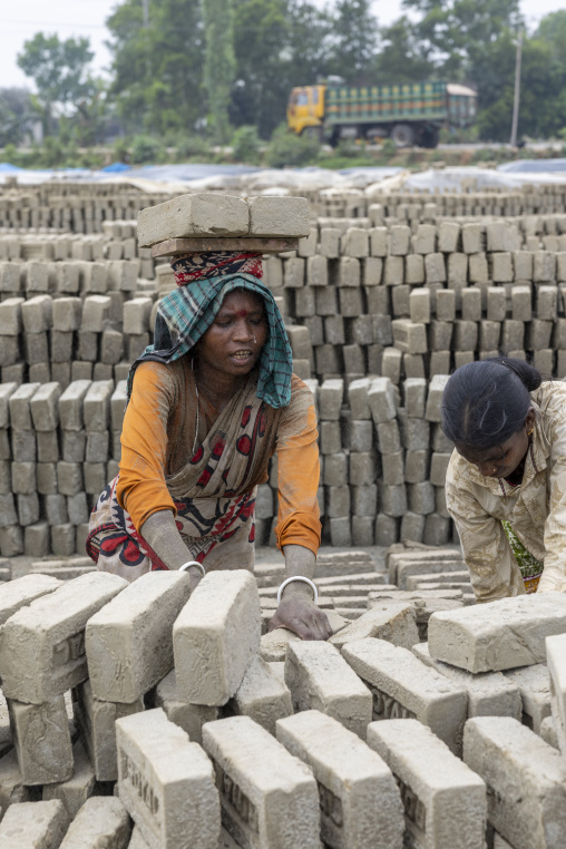 Women carrying bricks on their heads at a brick factory, Sylhet Division, Bahubal, Bangladesh
