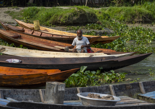 Bangladeshi man on a boat surrended by water hyacinths in Sundarbans, Barisal Division, Harta, Bangladesh