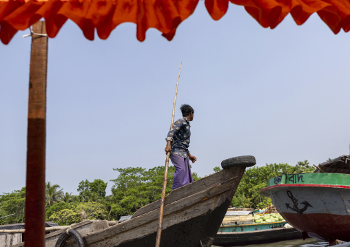 Bangladeshi man with a long stick on a boat in Sundarbans, Barisal Division, Wazirpur, Bangladesh