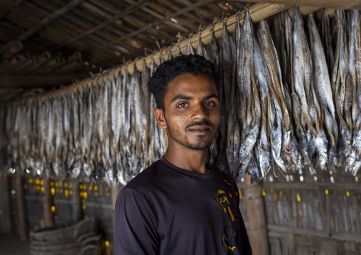 A male bangladeshi worker laids out fish inside a workshop, Chittagong Division, Cox's Bazar Sadar, Bangladesh
