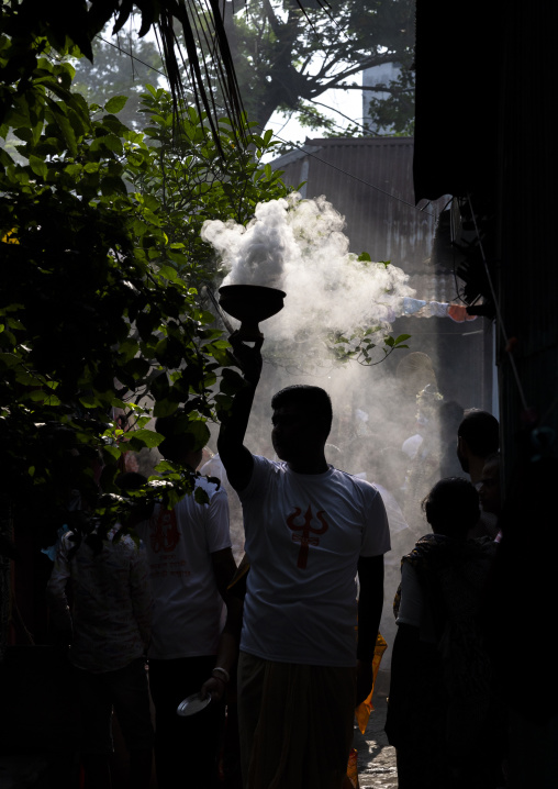 Hindu devotee silhouette holding a smoking incense burner, Dhaka Division, Munshiganj Sadar, Bangladesh