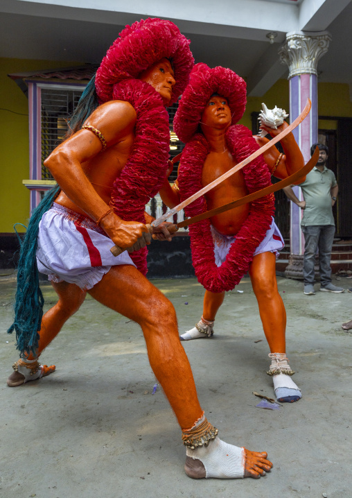Hindu devotees covered with orange color holding swords at Lal Kach festival, Dhaka Division, Munshiganj Sadar, Bangladesh