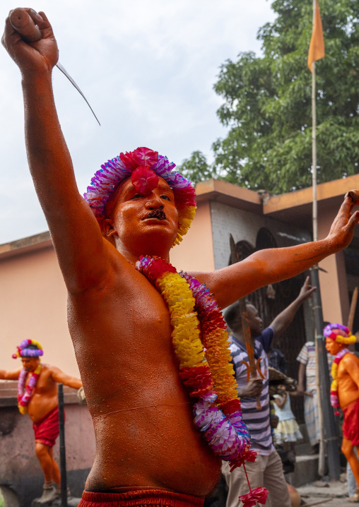 Hindu devotee with a sword covered with orange color at Lal Kach festival, Dhaka Division, Munshiganj Sadar, Bangladesh
