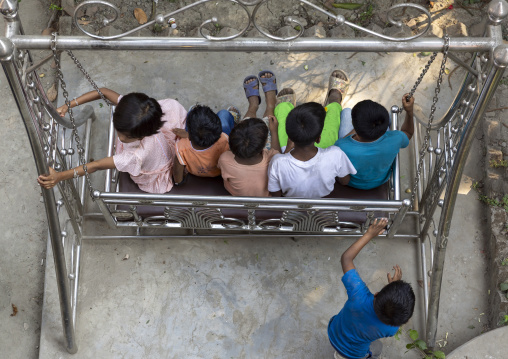 Bangladeshi children sit on a swing, Dhaka Division, Munshiganj, Bangladesh