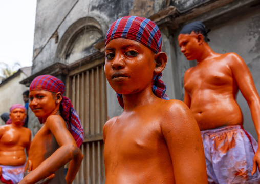 Young hindu devotees covered with orange color at Lal Kach festival, Dhaka Division, Munshiganj, Bangladesh