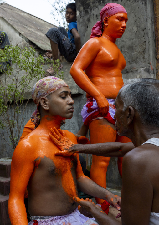Make up of a Hindu devotee covered with orange color at Lal Kach festival, Dhaka Division, Munshiganj, Bangladesh