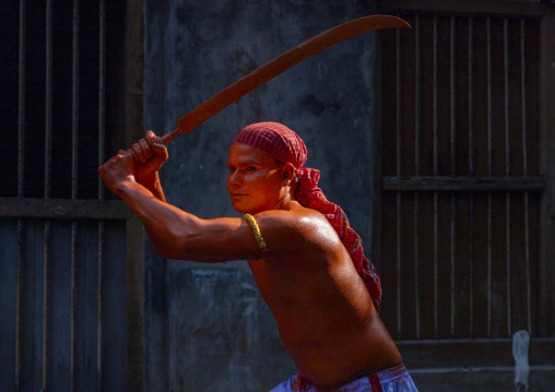 Hindu devotee with sword covered with orange color at Lal Kach festival, Dhaka Division, Munshiganj, Bangladesh