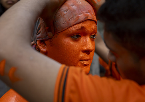 Make up of a Hindu devotee covered with orange color at Lal Kach festival, Dhaka Division, Munshiganj, Bangladesh
