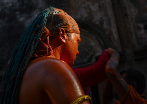 Portrait of a Hindu devotee covered with orange color at Lal Kach festival, Dhaka Division, Munshiganj, Bangladesh