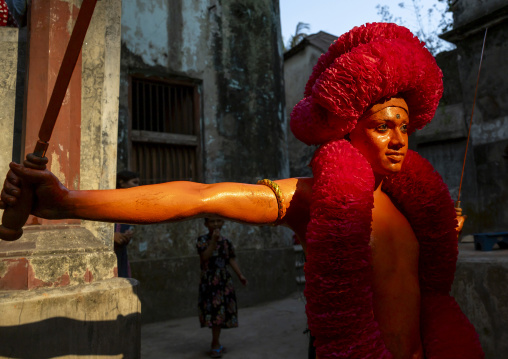 Hindu devotee with sword covered with orange color at Lal Kach festival, Dhaka Division, Munshiganj, Bangladesh