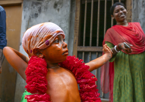 Young hindu devotee in orange color playing with sword at Lal Kach festival, Dhaka Division, Munshiganj, Bangladesh