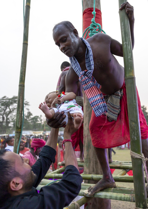 Devotee blessing a baby after body suspension during Charak Puja, Sylhet Division, Kamalganj, Bangladesh