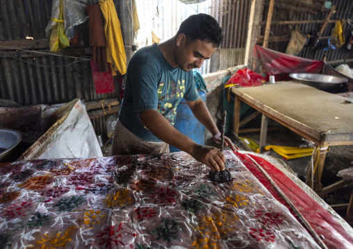 Bangladeshi man stamping wax on a cloth in a batik factory, Chittagong Division, Comilla, Bangladesh