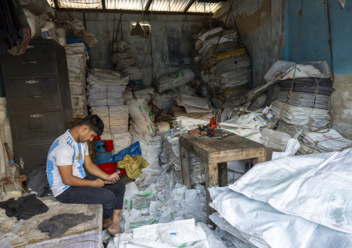 Bnagladeshi man recycling plastic bags in a factory, Chittagong Division, Chittagong, Bangladesh