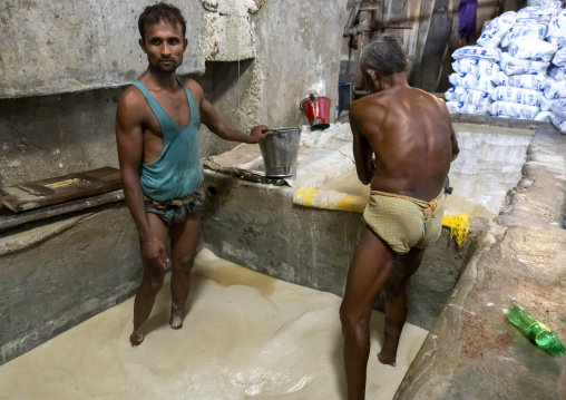 Bangladeshi men washing salt in water in a factory, Chittagong Division, Chittagong, Bangladesh