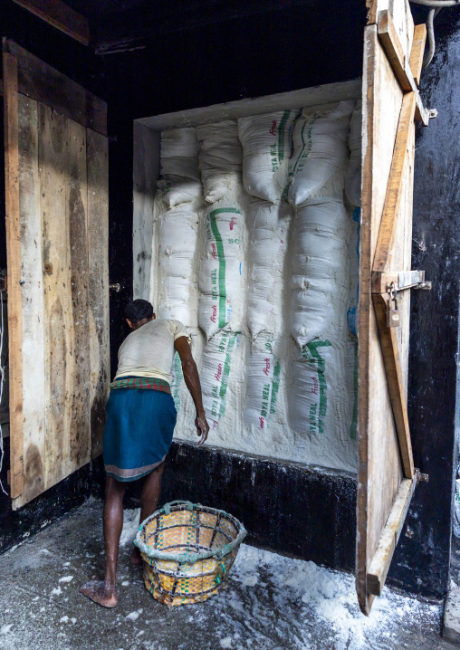 Bangladeshi man packing salt in a warehouse, Chittagong Division, Chittagong, Bangladesh