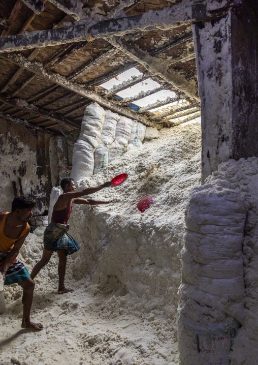 Bangladeshi men pick up salt in a warehouse, Chittagong Division, Chittagong, Bangladesh
