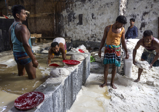 Bangladeshi workers washing salt in water in a factory, Chittagong Division, Chittagong, Bangladesh