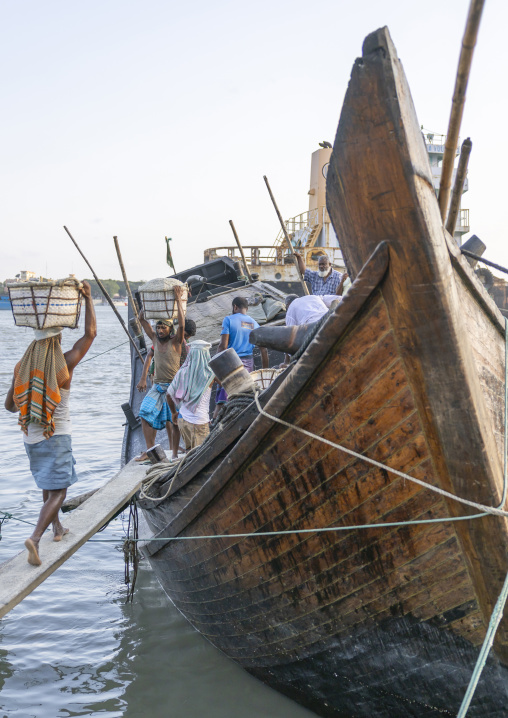 Bangladeshi men unloading salt in baskets from a boat, Chittagong Division, Chittagong, Bangladesh
