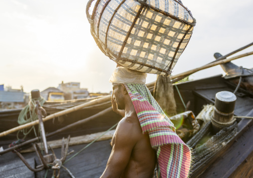 Bangladeshi man weighing basket with salt at a factory, Chittagong Division, Chittagong, Bangladesh