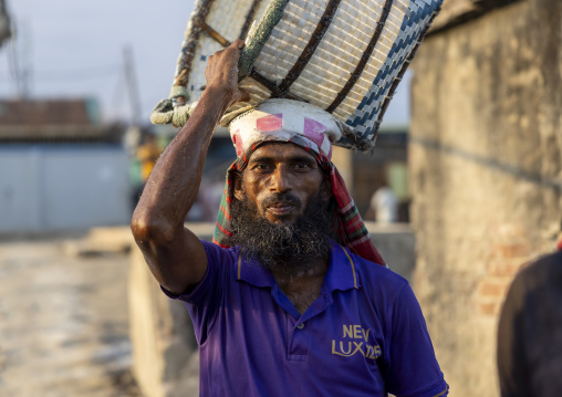 Bangladeshi man weighing basket with salt at a factory, Chittagong Division, Chittagong, Bangladesh