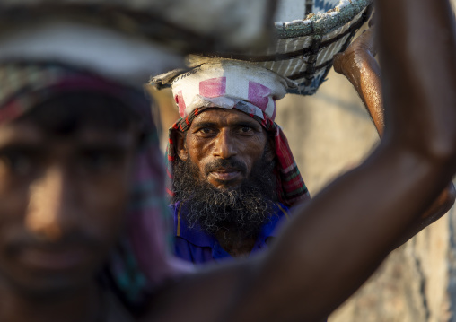 Bangladeshi men weighing baskets with salt at a factory, Chittagong Division, Chittagong, Bangladesh