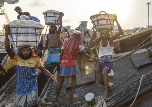 Bangladeshi men unloading salt in baskets from a boat, Chittagong Division, Chittagong, Bangladesh