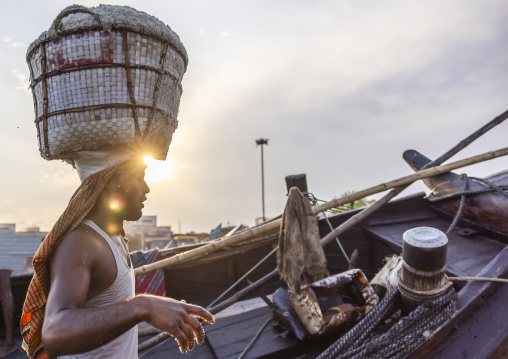 Bangladeshi man weighing basket with salt at a factory, Chittagong Division, Chittagong, Bangladesh