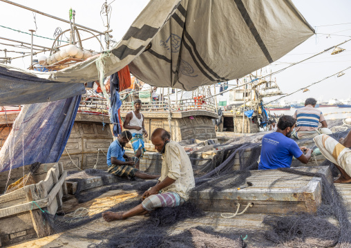 Bangladeshi men repairing fishing nets in a trawler, Chittagong Division, Chittagong, Bangladesh